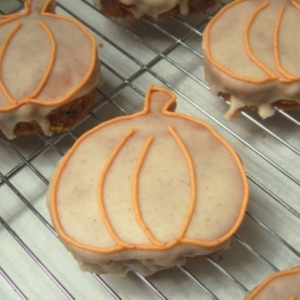 pumpkin bars shaped like a pumpkin on a cooling rack with orange detail icing