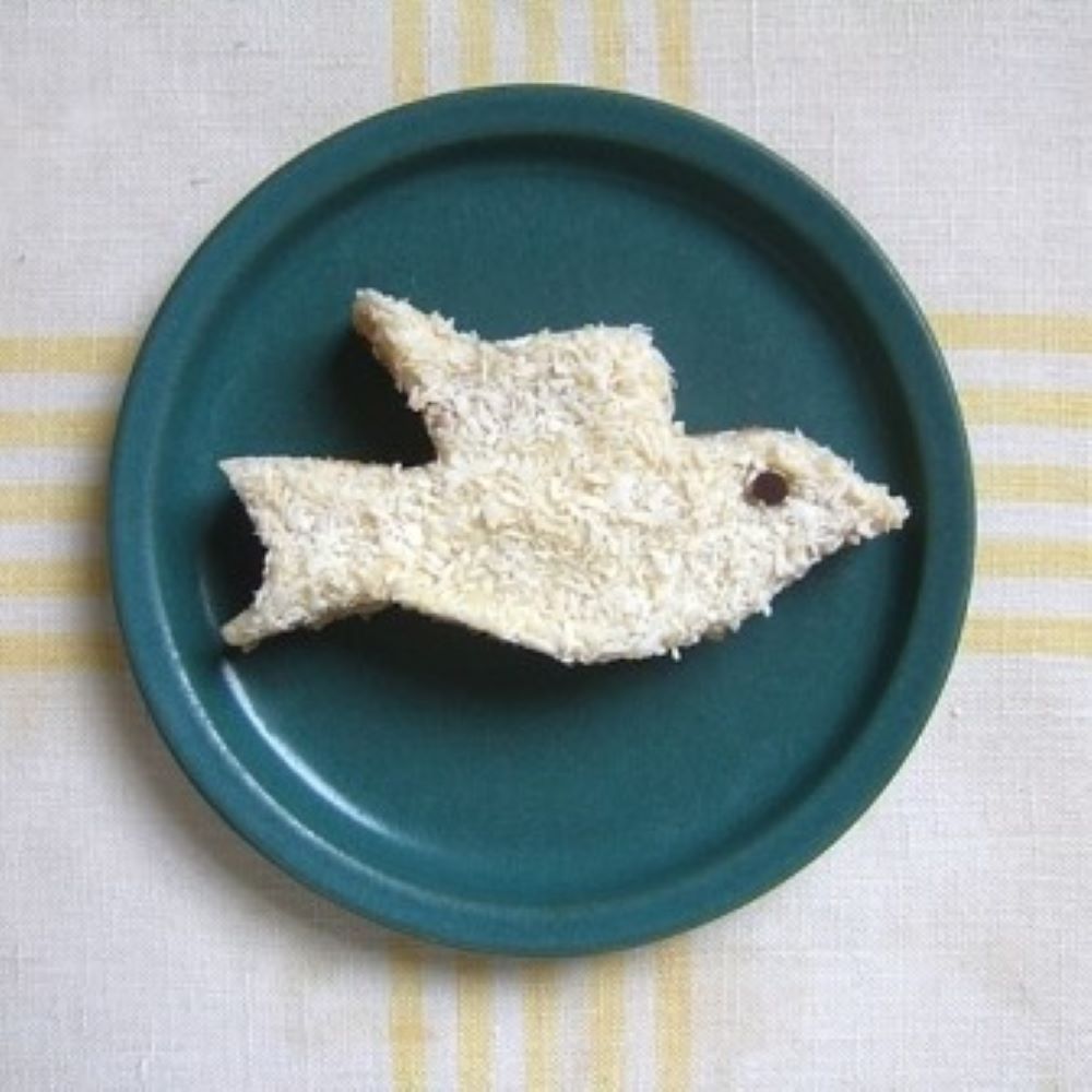 a bird shaped congo bar on a blue plate with a yellow and white striped tablecloth