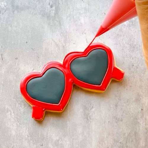 Cookie being decorated with red icing