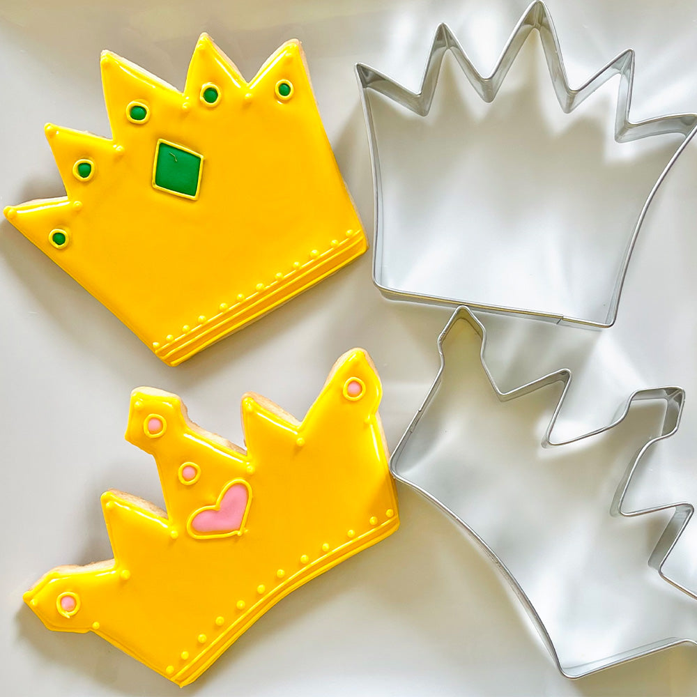 Crown cookies and cookie cutters on a white plate