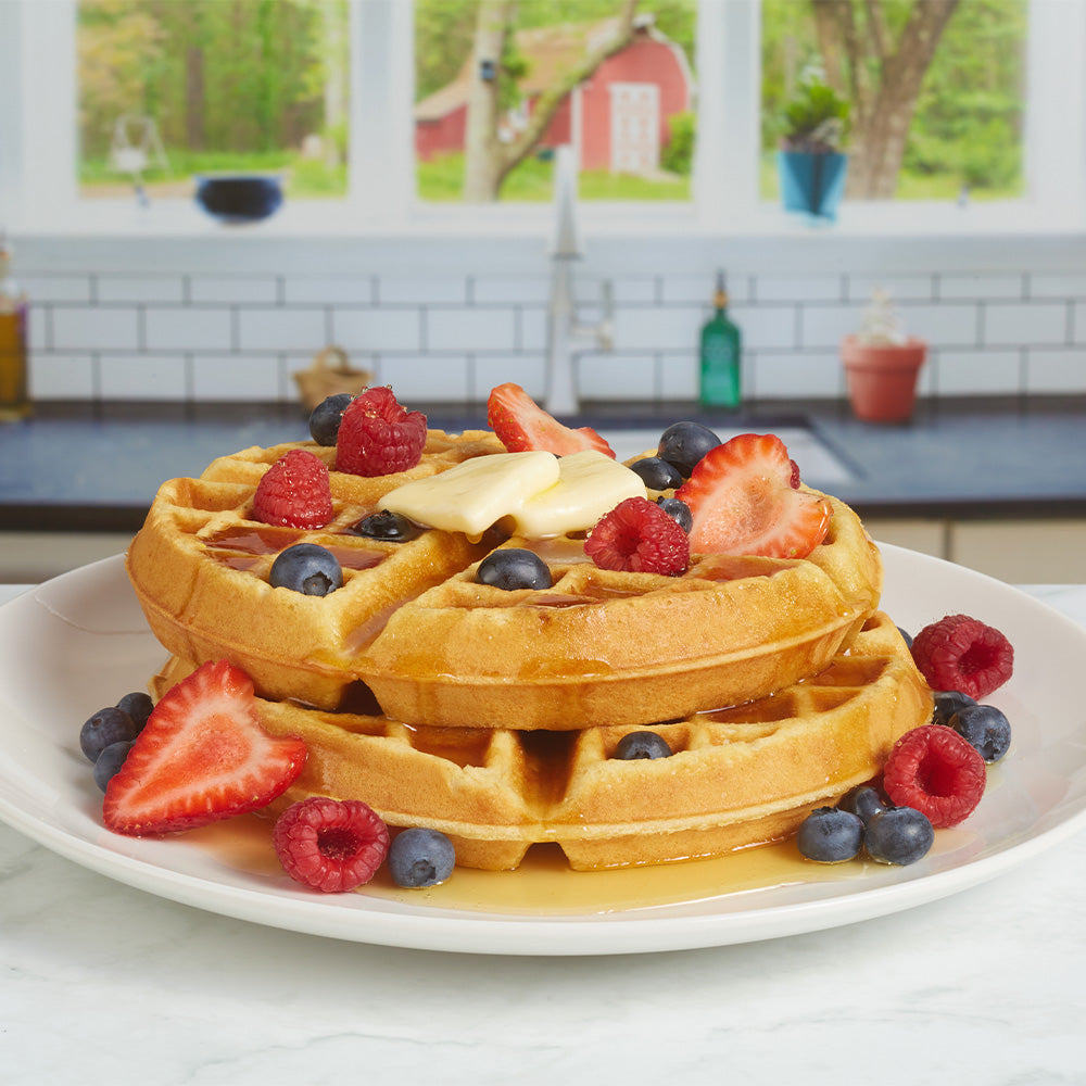 two waffles with fruit and syrup on a plate