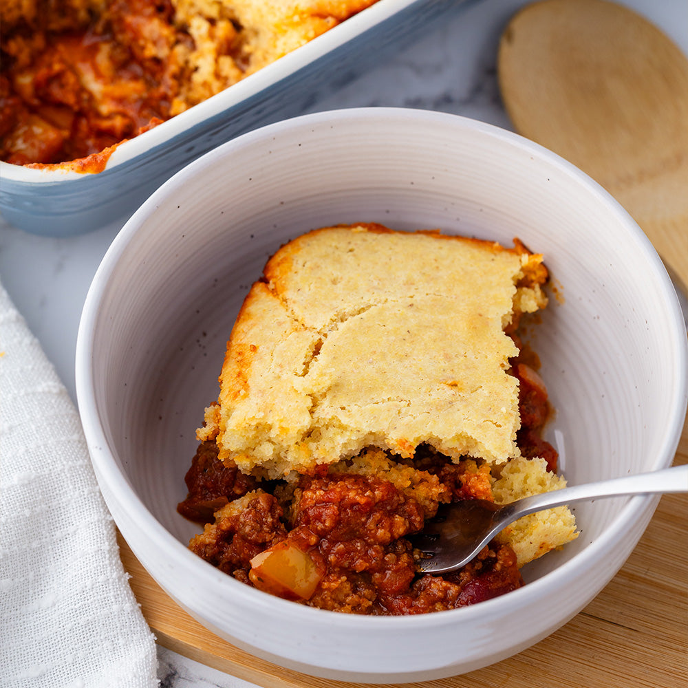 Chili cornbread casserole in a white stoneware bowl