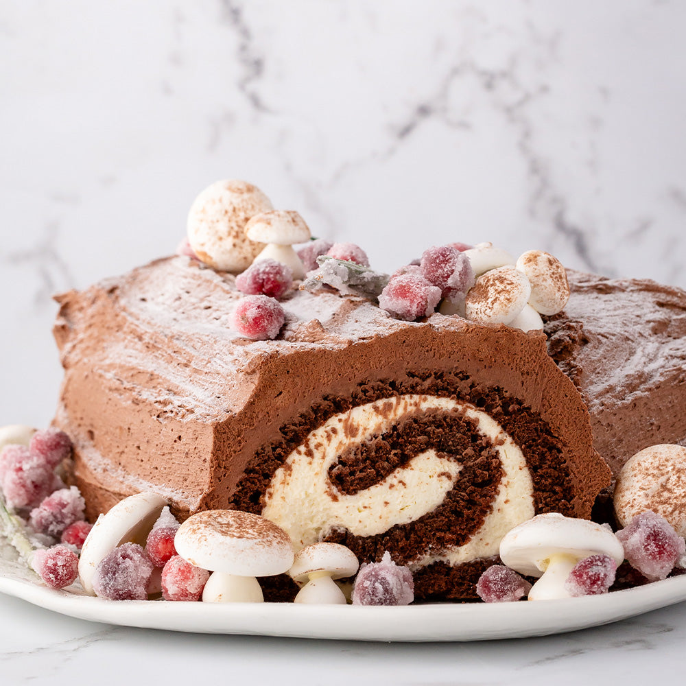 Yule log or buche de noel surrounded by meringue mushrooms