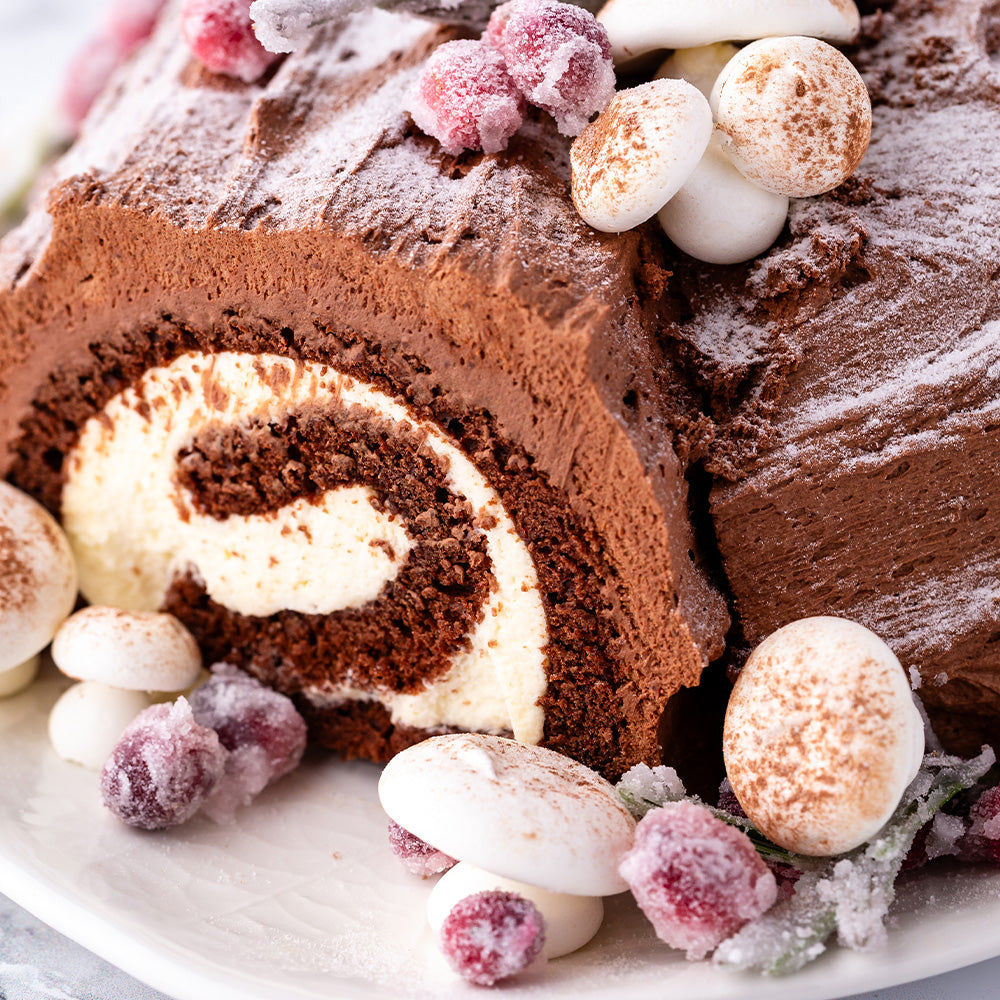 Meringue mushrooms next to a yule log cake