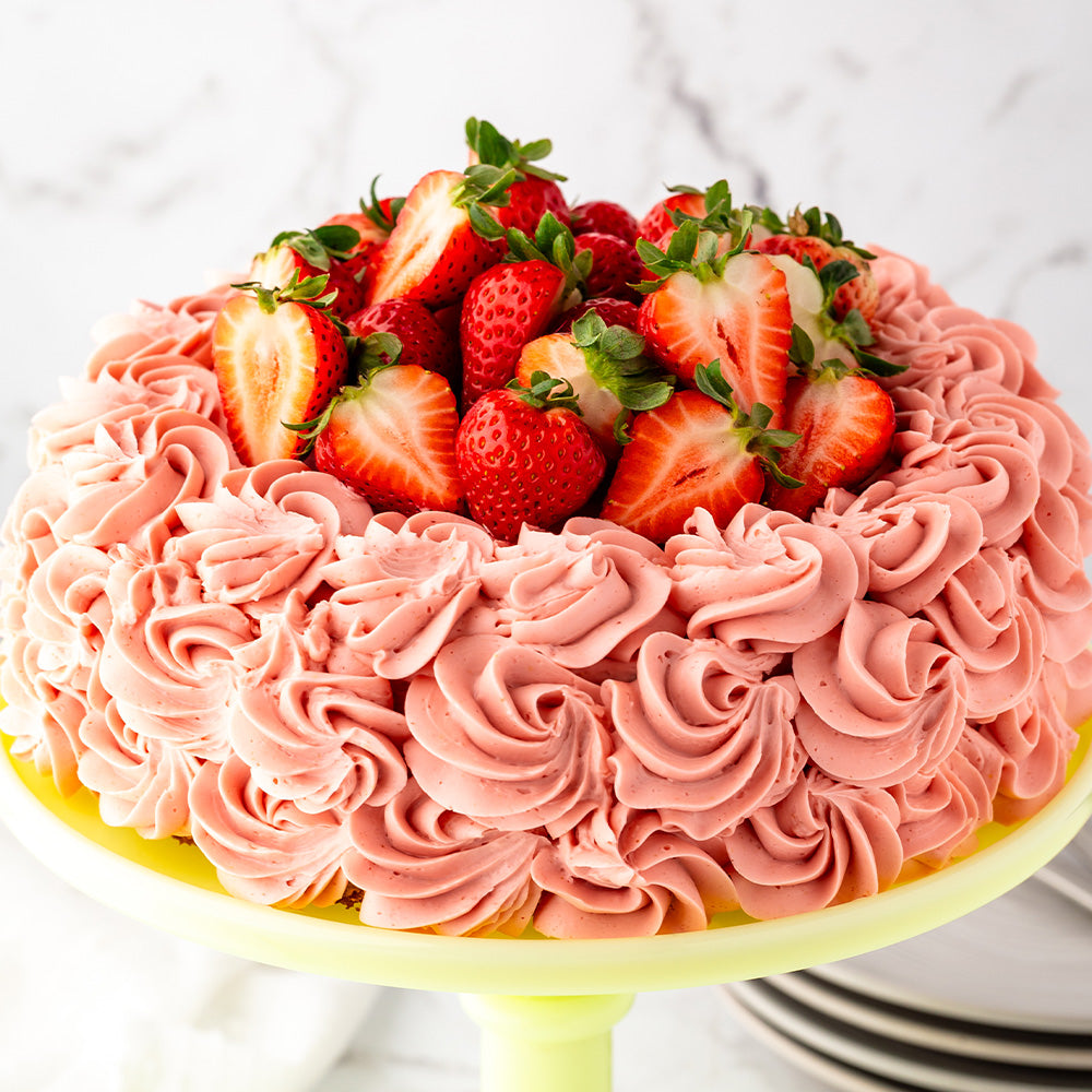 Cake with strawberry frosting and fresh strawberries