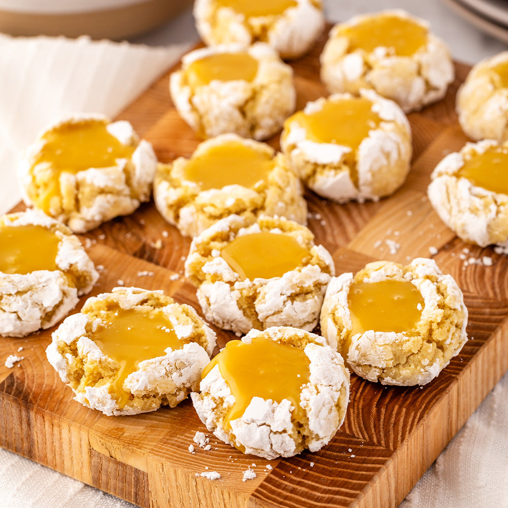 Lemon thumbprint cookies on a wooden serving board