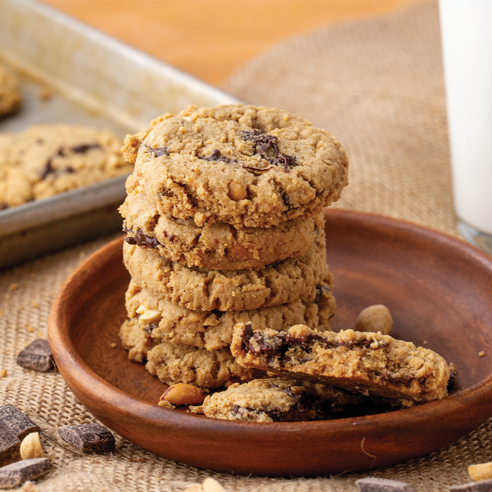 Stack of peanut butter chocolate chunk cookies on a wooden plate