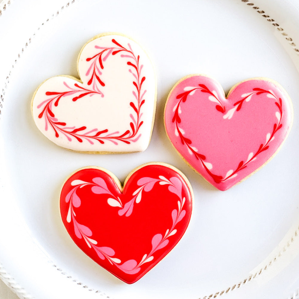 3 heart cookies on a white plate