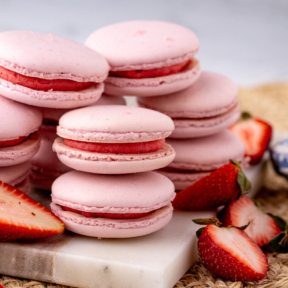 Stack of strawberry macarons with fresh strawberries